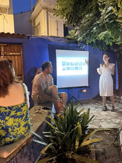 An evening photo projection in a courtyard, with participants watching the presentation.